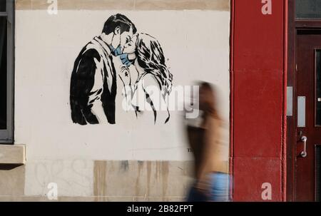 Ein Kunstwerk des Künstlers, bekannt als Rebel Bear, ist an einer Wand in der Bank Street in Glasgow aufgetaucht. Die neue Ergänzung zu Glasgows Straßenkunst erfasst die globale Coronavirus Krise. Das Stück zeigt eine Frau und einen Mann, der sich zurückzieht, um sich gegenseitig einen Kuss zu geben. Stockfoto