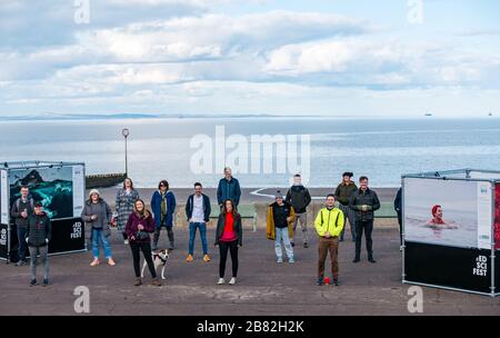 Portobello Promenade, Edinburgh, Schottland, Großbritannien. März 2020. Edinburgh Science Festival: Die einzige Veranstaltung im inzwischen abgebrochenen Programm aufgrund der Pandemie von Covid-19 Coronavirus ist eine Open-Air-Ausstellung namens "Into the Blue" mit Fotos zur Feier des Jahres der Küsten und Gewässer Schottlands. Das Team des Science Festivals übt soziale Distanzierung aus Stockfoto