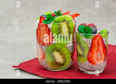 Quinoa chia Samen Dessert mit Mandeln Milch Erdbeere Himbeere Blaubeere Kiwi frische Minznapkin Stockfoto