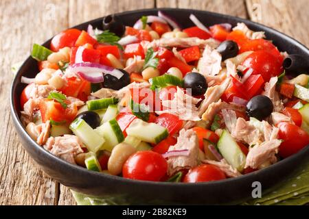 Thunfischsalat aus Konserven mit frischem Gemüse und Bohnen in einem Teller auf dem Tisch. Horizontal Stockfoto