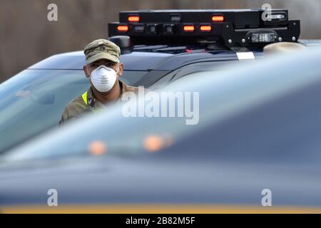 New York City, USA. März 2020. Ein Mitglied der Nationalgarde der New Yorker Armee wartet darauf, dass Autos in das erste Testzentrum von New York City Coronavirus im Abschnitt South Beach des New Yorker Stadtbezirks Staten Island, NY, am 19. März 2020 kommen. Diejenigen, die auf den tödlichen Virusausbruch getestet werden möchten, werden gebeten, ihre Fenster hochzurollen und ihre Identifikation gegen ihr Autofenster zu drücken. (Anthony Behar/Sipa USA) Credit: SIPA USA/Alamy Live News Stockfoto