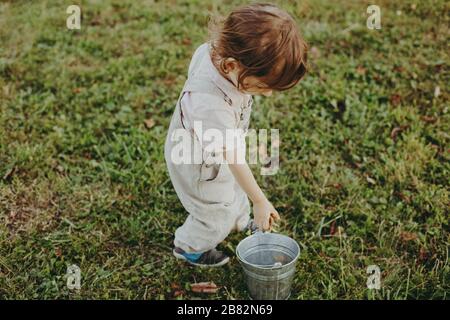 Leben im Freien auf einem Bauernhof auf dem Land in Frankreich, ein kleiner Junge, der an alltäglichen Aktivitäten wie dem Hängen der Wäsche zum Trocknen teilnimmt. Stockfoto