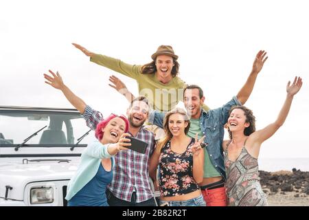 Gruppenjunge Freunde, die selfie während der Fahrt mit mobilen Smartphones nehmen - glückliche Reiseleute, die im Urlaub Spaß haben Stockfoto