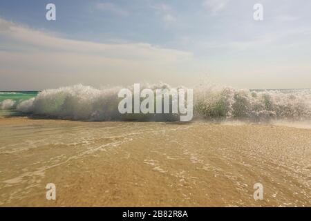 Die große Welle im karibischen Meer bricht die Küste. Eagle Beach auf der Insel Aruba. Schöner Naturhintergrund. Stockfoto