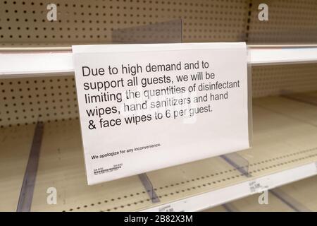 Leere Regale und ein Schild bezüglich der Produktrationierung sind in einem Zieleinzelhandel in Contra Costa County, San Ramon, Kalifornien, zu sehen, da die Bewohner bei einem Ausbruch des COVID-19 Coronavirus am 12. März alle verfügbaren Vorräte an toilettenpapier, Papiertüchern, Konserven, Handdesinfektionsmittel und anderen wichtigen Gegenständen kaufen. 2020. () Stockfoto