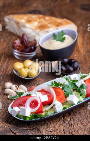 Oliven und Hummus auf dunklem Holz Stockfoto