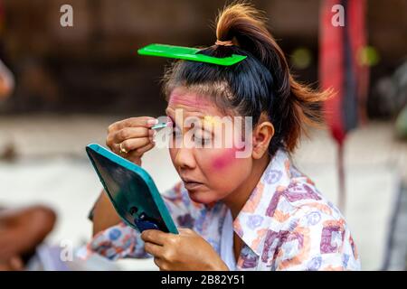 Eine Frau wendet Make Up an, bevor sie in EINER traditionellen balinesischen Barong und Kris Dance Show, Batabulaan, Bali, Indonesien, auftrat. Stockfoto