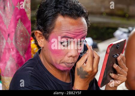 Ein männlicher Darsteller trifft Make Up zu, bevor er in EINER traditionellen balinesischen Barong und Kris Dance Show, Batabulaan, Bali, Indonesien, auftrat. Stockfoto