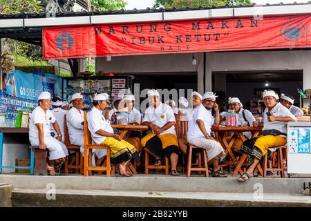 Eine Gruppe balinesischer Hindu-Männer, die in EINEM Restaurant, dem Besakih-Tempel, Bali, Indonesien sitzen. Stockfoto