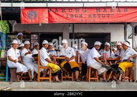 Eine Gruppe balinesischer Hindu-Männer, die in EINEM Restaurant, dem Besakih-Tempel, Bali, Indonesien sitzen. Stockfoto