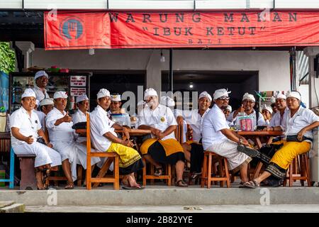 Eine Gruppe balinesischer Hindu-Männer, die in EINEM Restaurant, dem Besakih-Tempel, Bali, Indonesien sitzen. Stockfoto