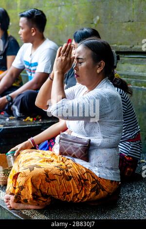 Eine balinesische Hindu-Frau, die im Wassertempel von Tyrta Emmul, Bali, Indonesien, bettet. Stockfoto