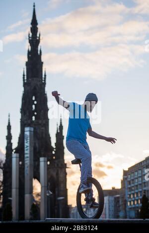 Edinburgh, Großbritannien. März 2020. Bild: Andrew Buchan, ein Stunt- und Extrem-Unicycler, vergeht die Zeit während einer normalerweise geschäftigen Hauptverkehrszeit in Edinburgh, aber aufgrund der Coronavirus Pandemie ist das Stadtzentrum extrem ruhig. Die Menschen stehen nun vor der Herausforderung, während der Selbsteingrenzung verschiedene Dinge mit ihrer Zeit zu tun. Das Scott Monument ist im Hintergrund zu sehen, das ein wichtiges Wahrzeichen von Edinburgh ist. Kredit: Colin Fisher/Alamy Live News Stockfoto