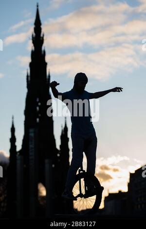 Edinburgh, Großbritannien. März 2020. Bild: Andrew Buchan, ein Stunt- und Extrem-Unicycler, vergeht die Zeit während einer normalerweise geschäftigen Hauptverkehrszeit in Edinburgh, aber aufgrund der Coronavirus Pandemie ist das Stadtzentrum extrem ruhig. Die Menschen stehen nun vor der Herausforderung, während der Selbsteingrenzung verschiedene Dinge mit ihrer Zeit zu tun. Das Scott Monument ist im Hintergrund zu sehen, das ein wichtiges Wahrzeichen von Edinburgh ist. Kredit: Colin Fisher/Alamy Live News Stockfoto