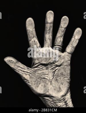 Ältere Hand vor schwarzem Hintergrund, mit Palm-Kamera geöffnet Stockfoto