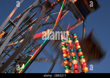 Lange Belichtung eines bunten Riesenrads in der Nacht Stockfoto