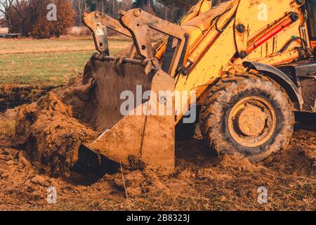 Grader, der den Boden abräumt und ausebnen soll, um Betonplatten zu installieren. Stockfoto