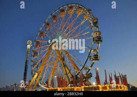 Lange Belichtung eines bunten Riesenrads in der Nacht Stockfoto