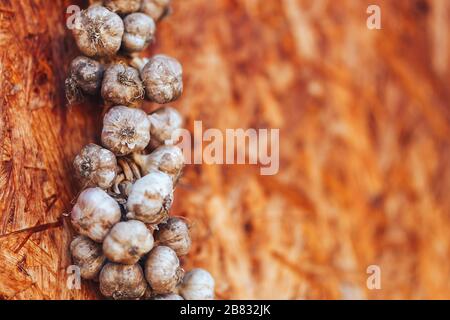 Knoblauchfigtail auf Holzhintergrund in der Ecke hängen Stockfoto