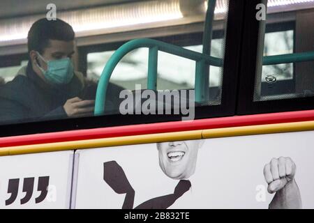 Stratford, London, Großbritannien. März 2020. Ein Mann, der eine chirurgische Maske trägt, sitzt im Bus in der Stratford Bus Station. Die Leute eilten, um die restlichen Artikel rund um das Stratford Shopping Center zu kaufen, da sich Coronavirus in London ausbreitete. Credit: Marcin Nowak/Alamy Live News Stockfoto