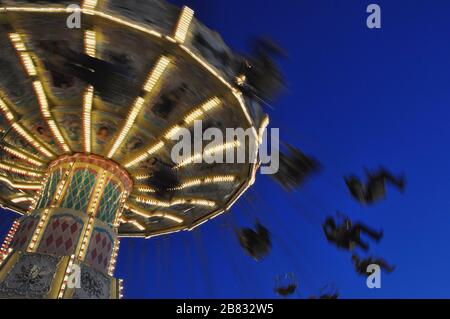 Lange Belichtung eines bunten Riesenrads in der Nacht Stockfoto