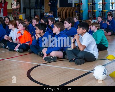 Schulkinder an der Hauptschule Davidsons Mains hören eine Präsentation in der Schulturnhalle in Edinburgh, Schottland, Großbritannien Stockfoto