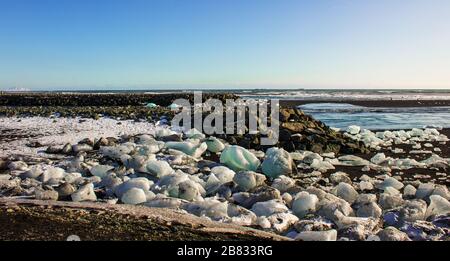 Eisfelder am schwarzen Kieselstrand, Küste von island Stockfoto