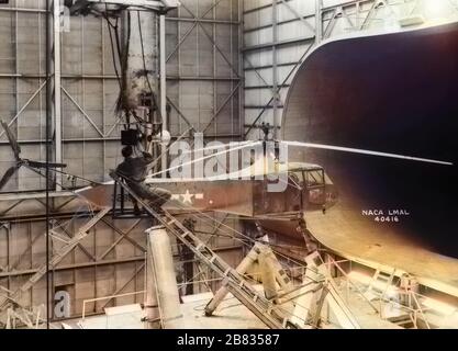 NASA-Techniker, der im 30 x 60 Full-Scale-Tunnel im Langley Research Center, Hampton, Virginia, am 19. Oktober 1944 Kameraausrüstung auf dem Sikorsky YR-4B/HNS-1 Hubschrauber aufstellt. Image Courtesy National Aeronautics and Space Administration (NASA). Hinweis: Das Bild wurde mit einem modernen Verfahren digital koloriert. Farben sind möglicherweise nicht periodengenau. () Stockfoto