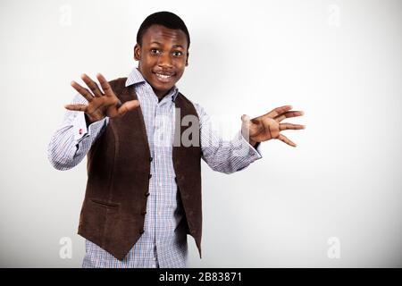 Junger positiver afrikaner in stilvoller Freizeitkleidung stehend und tanzend über weißem Hintergrund. Trendige Kleidung für Herren Konzept Stockfoto