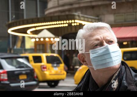 Ältere Menschen mit Gesundheits- und Sicherheitsbedenken tragen in Midtown Manhattan, New York City, USA, eine Gesichtsmaske Stockfoto