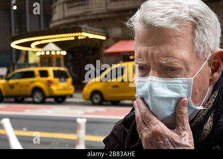 Ältere Menschen mit Gesundheits- und Sicherheitsbedenken tragen in Midtown Manhattan, New York City, USA, eine Gesichtsmaske Stockfoto