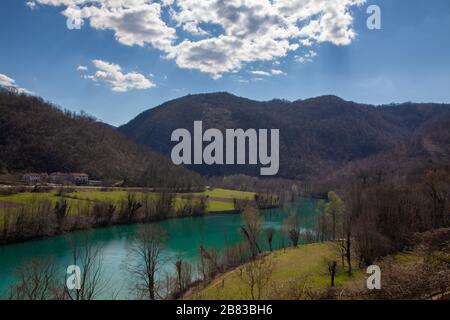 Weitwinkelaufnahme vom Dorf Prilesje im Winterfrühling Wechsel der Zeit zum Fluss Soca in ruhiger Kurve zum Kraftwerk in Solkan Stockfoto