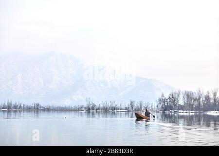 Srinagar, Jammu & Kashmir - 24. Januar 2020 - EIN Mann segelt sein Boot auf dem Dal Lake Stockfoto