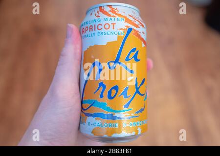 Nahaufnahme der Marke La Croix mit aromatisiertem Schaumwasser in der Hand eines Mannes mit hellem Holzhintergrund, San Ramon, Kalifornien, 7. Februar 2020. La Croix ist eine Marke der Muttergesellschaft National Beverage Corporation. () Stockfoto