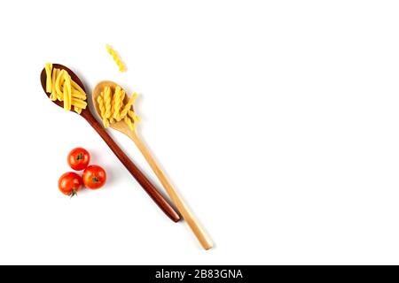 Zwei Arten von italienischem Nudelkonzept. Raw gemelli, Casarecce in Holzlöffeln, Tomaten auf weißem Hintergrund. Draufsicht, Kopierbereich. Stockfoto