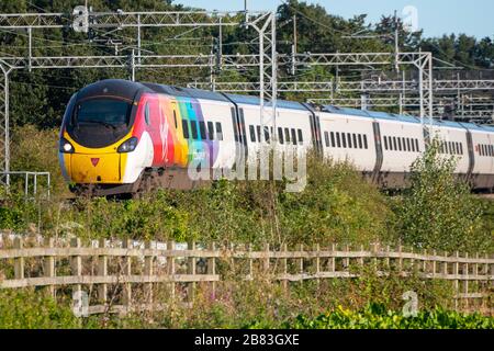 Virgin Class 390, Pendolino, elektrischer Neigezug in Regenbogenfarben, der schwulen Stolz feiert, vorbei an Esenhall, in der Nähe von Rugby, Warwickshire, England Stockfoto