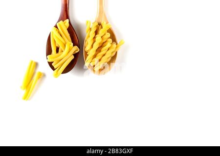 Zwei Arten von italienischem Nudelkonzept. Raw gemelli, Casarecce in Holzlöffeln auf weißem Hintergrund. Draufsicht, Kopierbereich. Stockfoto