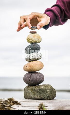 Ein Mann, der Steine übereinander balanciert. Stockfoto