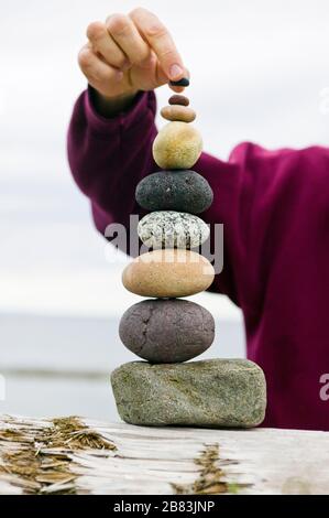 Ein Mann, der Steine übereinander balanciert. Stockfoto