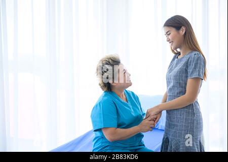 Junger hilfsbereiter Arzt, der sich um eine ältere Frau im Pflegeheim kümmert Stockfoto