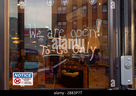 An der Tür eines Cafés in New York zu schreiben, dass es nur wegen des Coronavirus oder der Kovid-19-Pandemie geöffnet sei Stockfoto