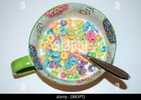 Nahaufnahme einer Schüssel voller Zucker mit Fruchtgeschmack, die bereit ist, Frühstückszerealien mit einem Löffel zu essen Stockfoto