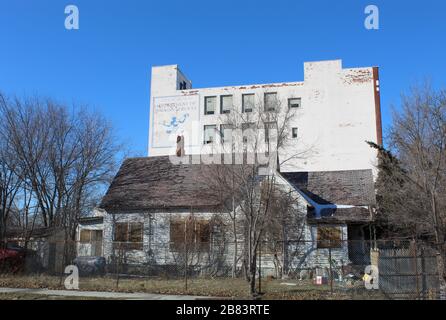 Verlassenes Bürogebäude des Detroit Department of Human Services mit einem verlassenen Haus davor Stockfoto