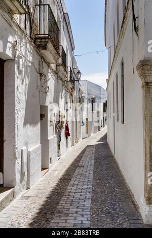 Eine der engen gepflasterten Straßen im historischen weißen Dorf Arcos de la Frontera, Provinz Cadiz, Andalusien (Andalucia). Spanien. Europa Stockfoto