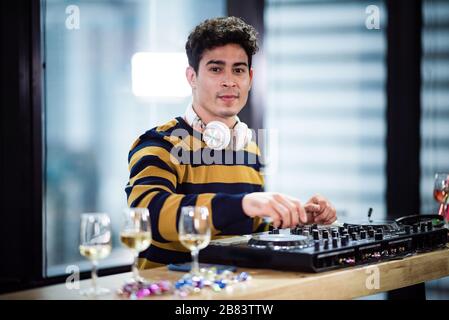 Männlicher DJ, der auf Party Musik spielt Stockfoto