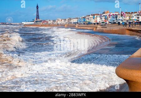 Blick auf die bei Flut einströmenden Wellen und die Kurve der neuen Meereswand mit Blackpool Tower und Central Pier in der Ferne. Blackpool Lancashire England Stockfoto