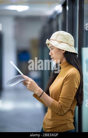 Junge Frauen lesen Präsentationsinformationen, um sich auf ein Bewerbungsgespräch vorzubereiten Stockfoto