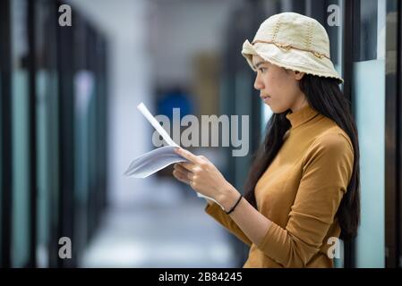 Junge Frauen lesen Präsentationsinformationen, um sich auf ein Bewerbungsgespräch vorzubereiten Stockfoto