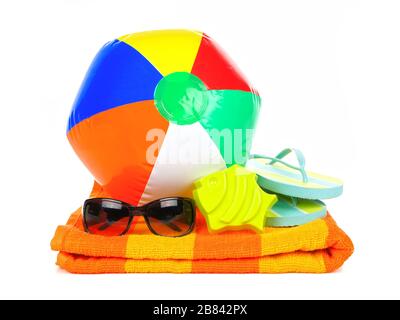 Strandball, Sonnenbrille und Flip-Flops auf orangefarbenem Handtuch isoliert auf Weiß Stockfoto