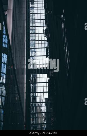 Panoramaaussicht und Perspektive Weitwinkelansicht zu stahlblauem Hintergrund von hoch aufragenden Gebäudehochhäusern aus Glas in der modernen futuristischen Innenstadt Stockfoto